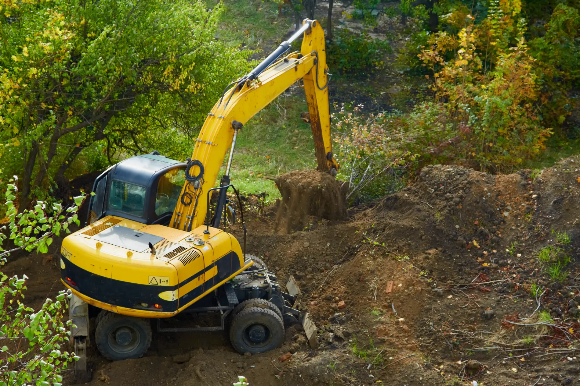 Mini excavator digging a trench in a residential yard