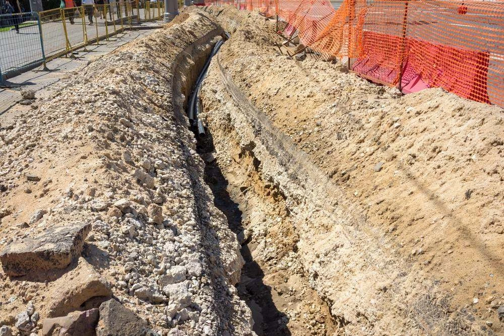 Excavator digging a trench on site